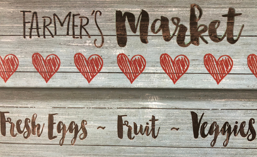 Rustic Farmer's Market sign showing fresh eggs fruit and veggies available.