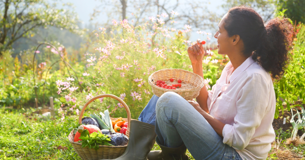 A smiling woman enjoying the permaculture fruits of her labor; it's the future of homesteading.